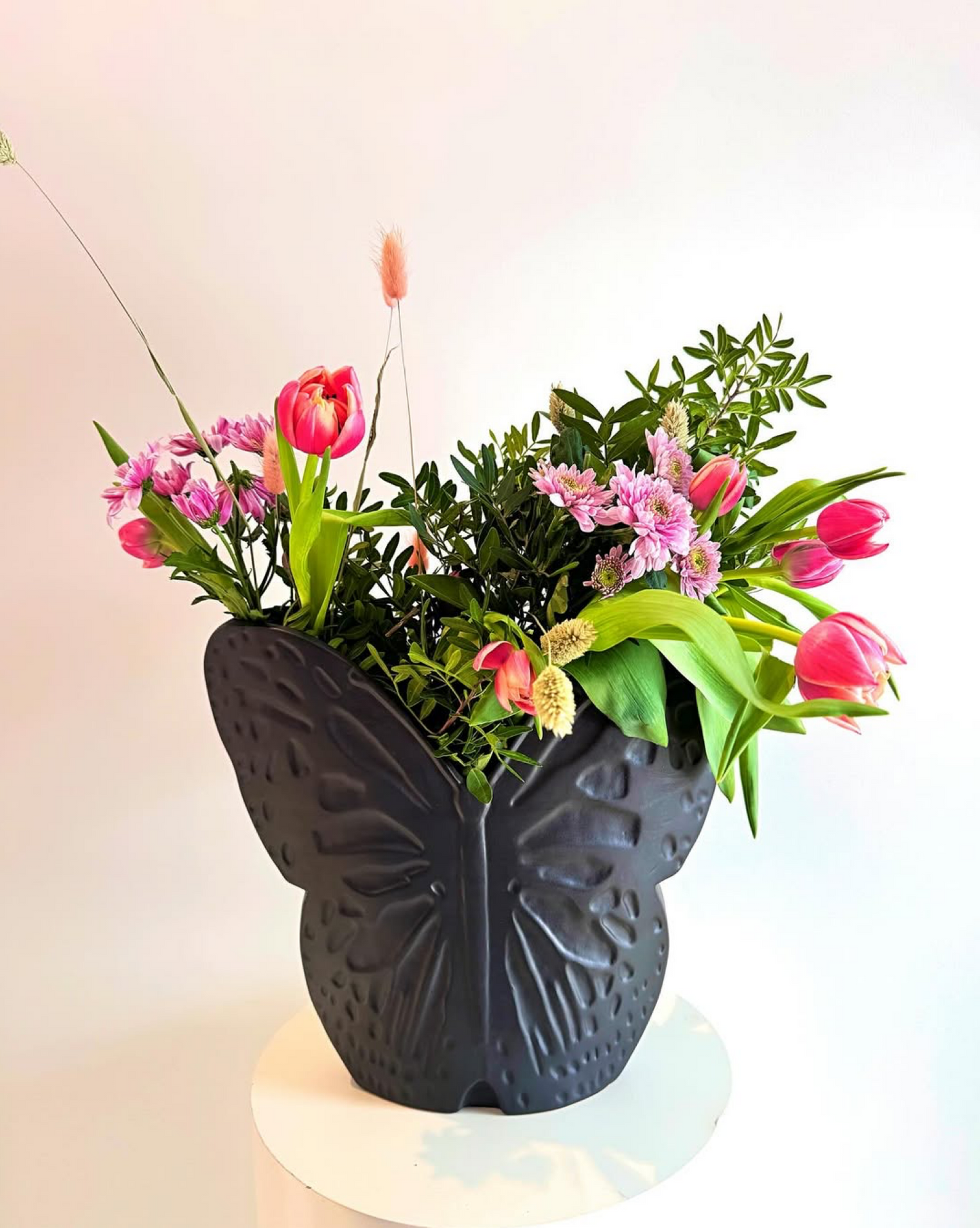 svart vas med blommor i