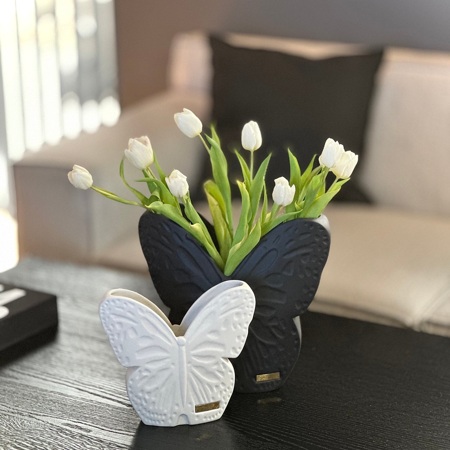 stor svart och liten vit vas på ett bord